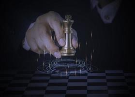 empresário segurando e jogando xadrez rei dourado para atingir o vencedor do negócio com sucesso na competição com fundo de rede de tecnologia. conceito de estratégia de gestão e liderança.