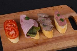 bruschetta com tomate, presunto e língua foto