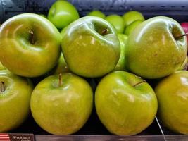 maçãs frescas verdes na prateleira do supermercado foto