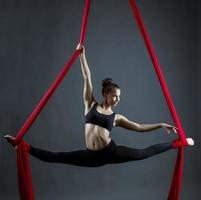 jovem flexível dançando usando fitas penduradas