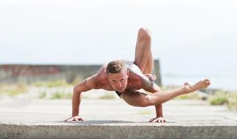 homem pratica ioga e ginástica foto