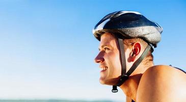 jovem de bicicleta com capacete na cabeça foto