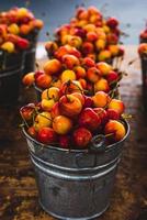 baldes de cerejas chuvosas vermelhas e amarelas foto