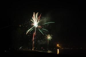 belos fogos de artifício comemorando o ano novo na praia foto