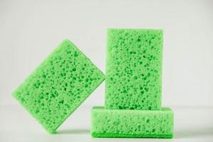 esponjas verdes para limpeza em um fundo branco foto
