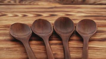 colheres de madeira de madeira escura em um fundo de mesa de madeira foto