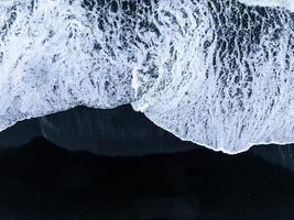 praia de areia preta da islândia com ondas enormes em reynisfjara vik. foto