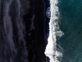 praia de areia preta da islândia com ondas enormes em reynisfjara vik. foto