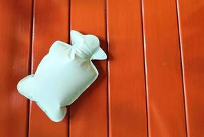 garrafa de água quente verde ou menta ou bolsa em fundo de madeira marrom para aliviar a dor menstrual foto