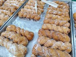 deliciosos donuts de açúcar torcido em uma bandeja, venda no supermercado foto