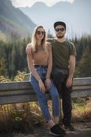 casal jovem turista, homem e mulher, na trilha nas montanhas foto