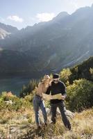 casal jovem turista, homem e mulher, na trilha nas montanhas foto