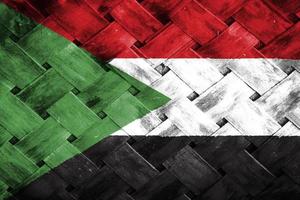 tela de bandeira do sudão em fundo de madeira de vime foto