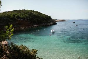 bela praia com água muito limpa e azul no mar mediterrâneo na ilha de ibiza, espanha. foto