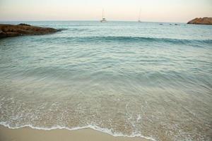 bela praia com água muito limpa e azul no mar mediterrâneo na ilha de ibiza, espanha. foto