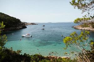 bela praia com água muito limpa e azul no mar mediterrâneo na ilha de ibiza, espanha foto