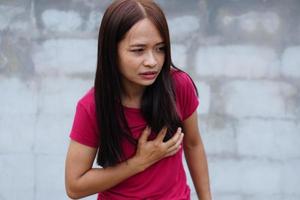 mulheres asiáticas têm aperto no peito. causada por doença cardíaca foto