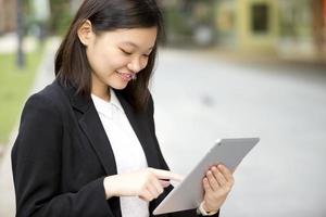 executivo de negócios asiáticos feminino jovem usando tablet