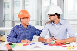 engenheiros masculinos alegres estão discutindo a construção