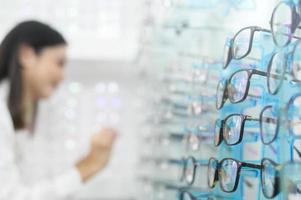jovem cliente do sexo feminino escolhendo óculos no centro óptico, conceito de cuidados com os olhos. foto