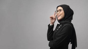 linda mulher muçulmana de óculos sobre estúdio de fundo branco foto