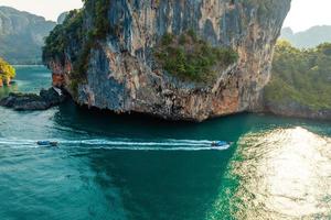 vista para o mar e ilhas rochosas com um barco de cauda longa. foto