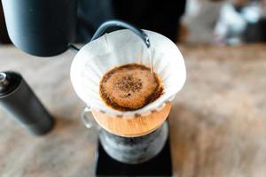 gotejamento de café, derramando água quente na chaleira no café, preparar café foto