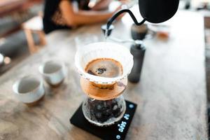 gotejamento de café, derramando água quente na chaleira no café, preparar café foto