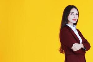 mulher caucasiana de negócios de terno vermelho sorrindo e inteligente isolado em fundo amarelo. foto