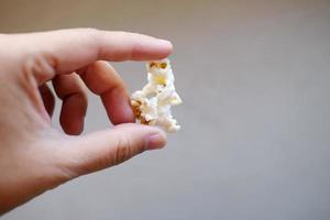 mão segurando deliciosa pipoca doce em sacos plásticos. foto