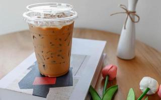 copo de plástico de café expresso frio em uma mesa de café foto