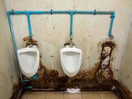 a fileira suja do mictório do banheiro temporário na estação ferroviária. foto
