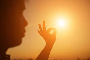 mãos formando um coração com silhueta por do sol foto
