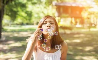 uma linda mulher soprando bolhas foto