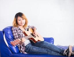 mulher jovem hippie tocando uma guitarra. foto
