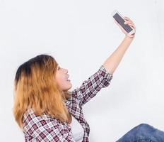 mulher jovem hippie feliz tirando foto de selfie no smartphone sobre fundo branco.