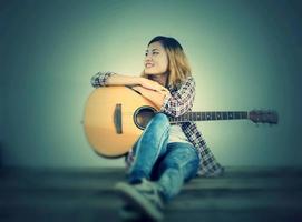 retrato de estilo de mulher hipster desfrutar com guitarra parece tão feliz. foto