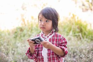 menina fotografa flor ao ar livre foto