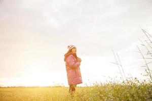 jovem estava jogando em um campo de flores no ar de inverno. foto