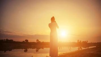 mulher de fotógrafo de silhueta por do sol foto