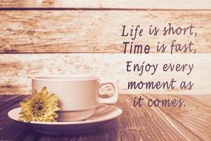 citação motivacional com xícara de café e flores na mesa de madeira. foto