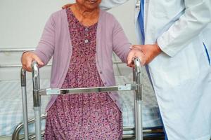 médico ajuda paciente idosa asiática com deficiência no hospital de enfermagem, conceito médico. foto