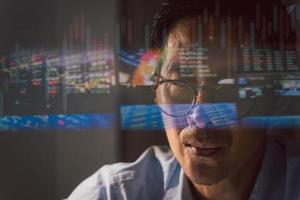 feche o comerciante trabalhando no laptop analisando o mercado de ações on-line com reflexão. foto