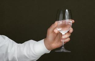 mão masculina com um copo de vinho de água