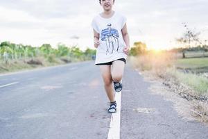 caminho para o sucesso, correndo na estrada com sapatos esportivos, mulher esportiva de estilo de vida saudável correndo, pernas femininas com tênis correndo à noite, prepare-se para a maratona foto