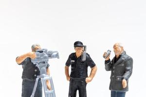 repórter em miniatura com microfone e cinegrafista entrevistando policiais foto