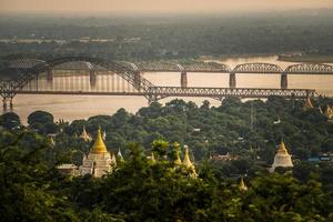 vista do templo e grupo de pagode com a ponte irrawaddy na cidade sagaing a antiga capital da antiga mianmar. foto