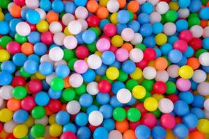 bolas de plástico multicoloridas e altamente saturadas, em uma piscina de bolinhas macias, em um parque infantil foto