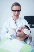 feminino dentista examinando mans dentes foto