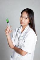 jovem médico feminino asiático com seringa